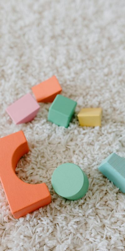 Vibrant wooden educational toys scattered on a soft beige carpet.
